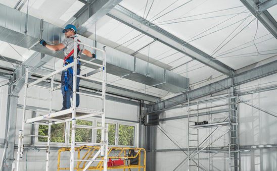 man on a platform installing metal cladding.